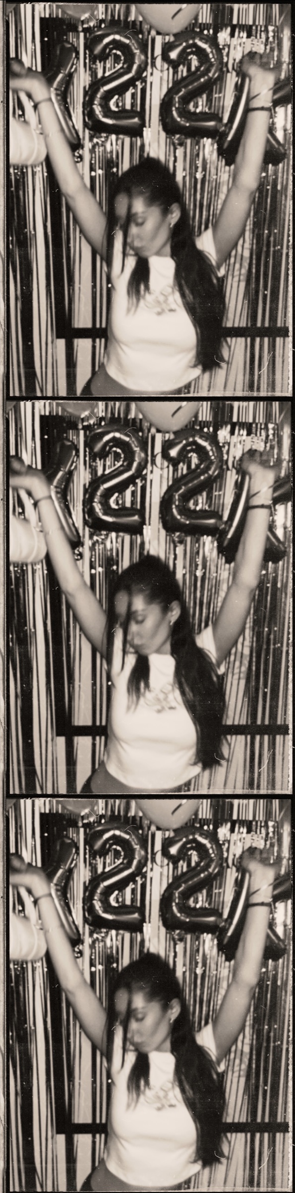 A photobooth strip of Eleni with balloons spelling 22